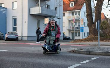 Theo Chatziavramidis überquert die Devizesstraße aus einer nahegelegenen Einmündung, damit er so wenig Bordsteine wie möglich pa