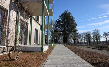 Im Sonnenschein der ersten Frühlingstage sieht das erste fertige Gebäube auf der Hangweide durchaus einladend aus - aber es herr