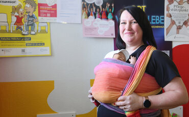 Als Trageberaterin weiß Tamara Krüger, wie das Baby - in diesem Fall eine Puppe - richtig in einem Tragetuch eingebunden ist.