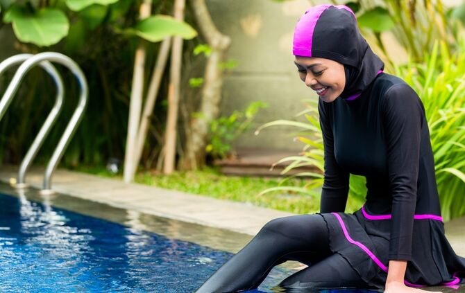 Muslim woman wearing Burkini swimwear at pool
