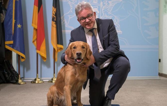 Guido Wolf sitzt neben dem Therapiebegleithund Watson
