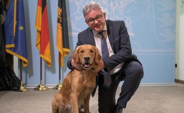 Guido Wolf sitzt neben dem Therapiebegleithund Watson