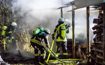 Feuerwehr löscht brennenden Holzstapel_0