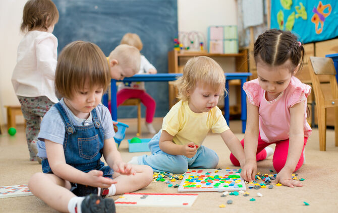 kids or children playing mosaic game in kindergarten room