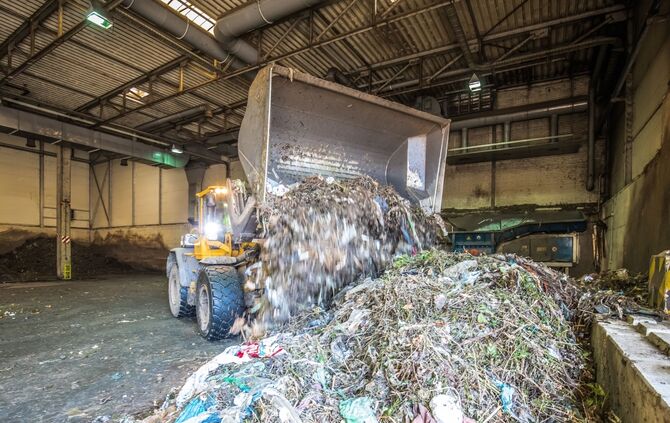Ein Schaufellader arbeitet an einem Haufen Biomüll // Biomüllkampagne im Rems-Murr-Kreis: Einladung zu einem Pressegespräch - Fotos sind im Anschluss an die PK beim Rundgang über die Vergärungsanlage möglich, Thema: Störstoffe im Biomüll.