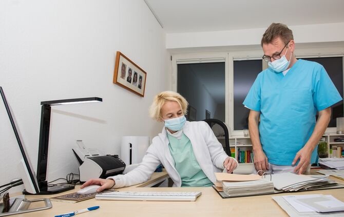 Wie läuft das Impfen?, Dr. Frank Röder und seine Assistentin bei der Terminplanung mit der Warteliste, Internistische Hausarztpr