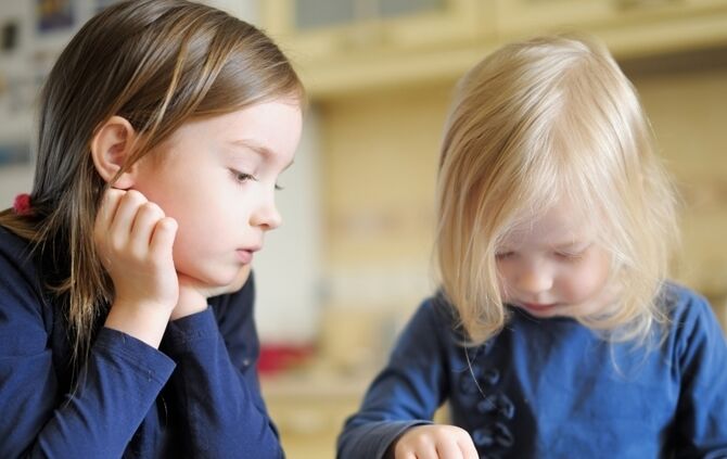 Two children playing with a digital tablet at home