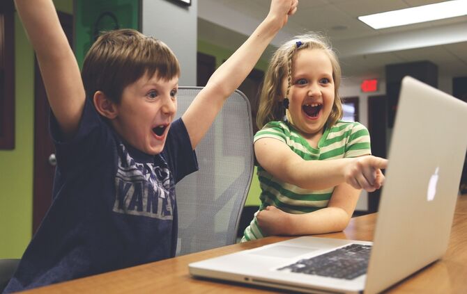 Kinder jubeln vor Laptop
