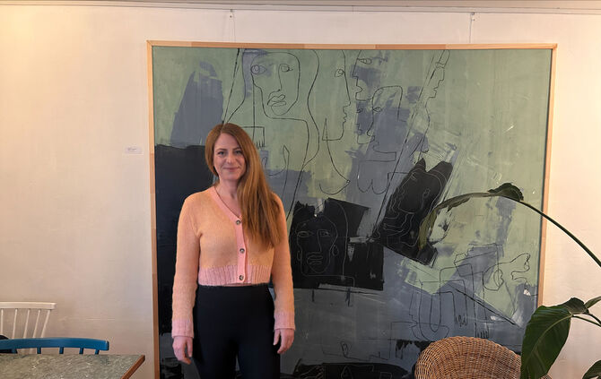 Die Künstlerin Bea Schlipf vor einem ihrer Bilder im Café Moody.