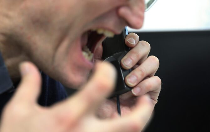 Mann schreit ins Telefon