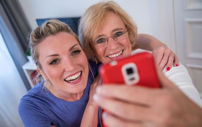 Zwei Frauen fotografieren sich mit einem Smartphone.