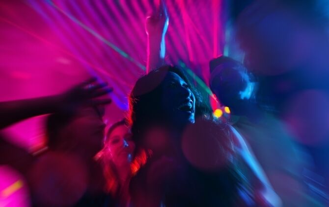 Party people dancing in disco or night club