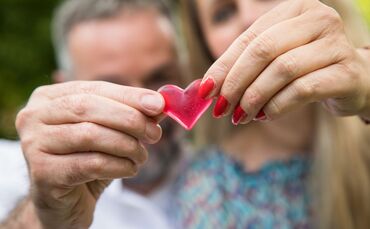 Eine Frau und ein Mann halten ein Herz in den Händen.
