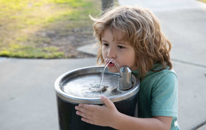 Refreshment solution. Thirsty kid drink water from drinking fountain. Thirst quenching