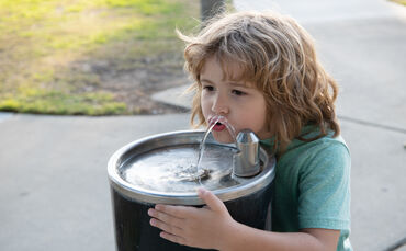 Refreshment solution. Thirsty kid drink water from drinking fountain. Thirst quenching