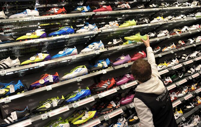 Ein Mann steht vor einem Regal mit Fußballschuhen