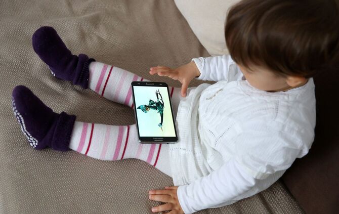 Ein Kleinkind nutzt ein Smartphone.
