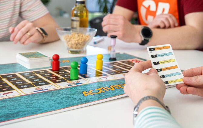 Drei Personen spielen eine Gesellschaftsspiel.