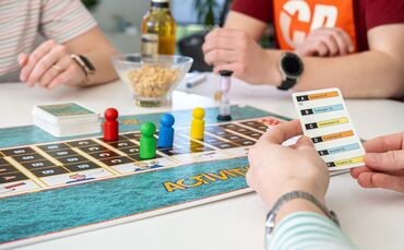 Drei Personen spielen eine Gesellschaftsspiel.