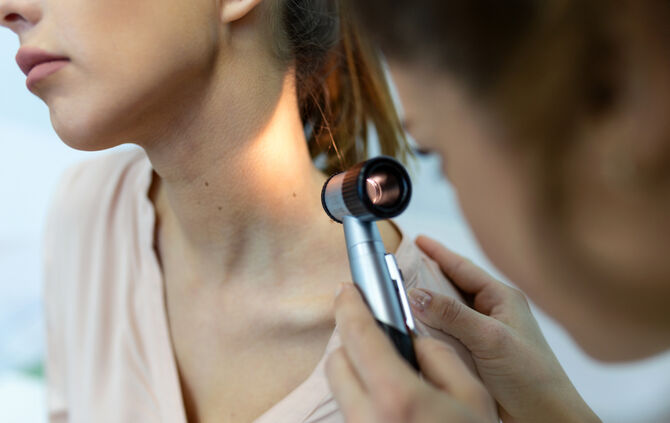 Doctor dermatologist examines skin of patient. Dermatoscopy, prevention of melanoma, skin cancer.