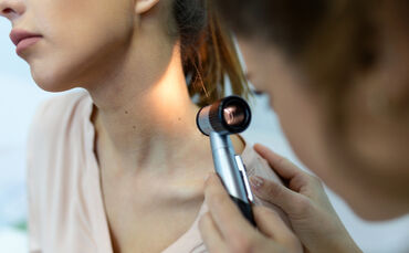 Doctor dermatologist examines skin of patient. Dermatoscopy, prevention of melanoma, skin cancer.
