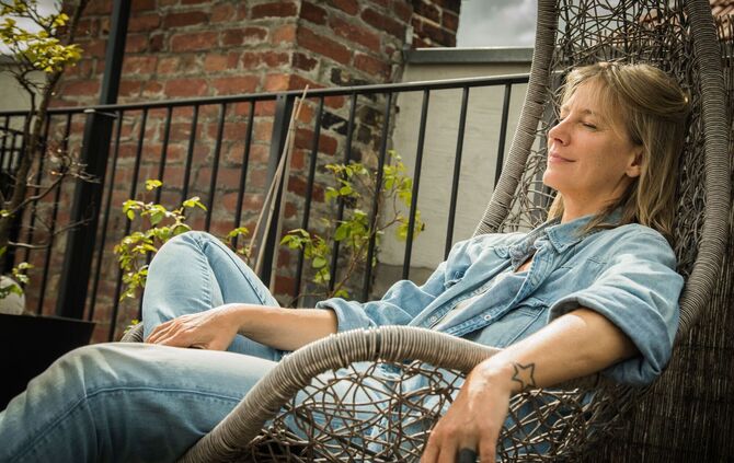 Frau sitzt entspannt in einem Hängesessel