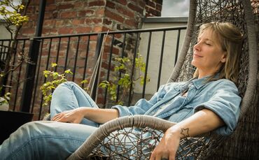 Frau sitzt entspannt in einem Hängesessel