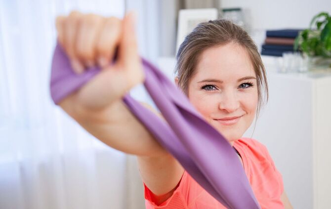 Frau trainiert mit einem Fitnessband