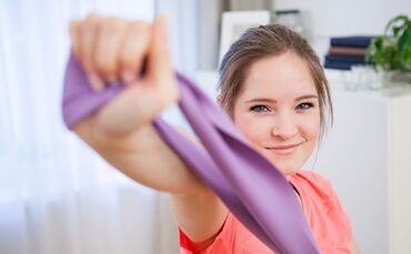 Frau trainiert mit einem Fitnessband