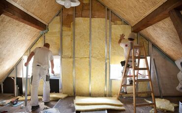 Zwei Handwerker dämmen das Dach