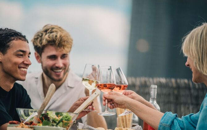 Freunde stoßen mit Wein an