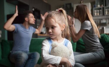 Kid daughter feeling upset while parents fighting at background