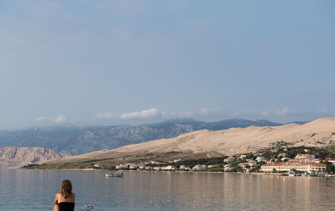 Eine Frau sitzt in Pag am Strand