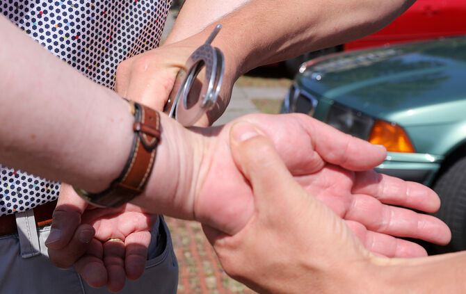 festnahme handschellen polizei blaulicht symbol symbolbild Symbolfoto