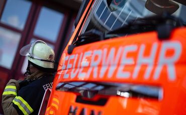 Feuerwehrmann steht neben einem Feuerwehrauto
