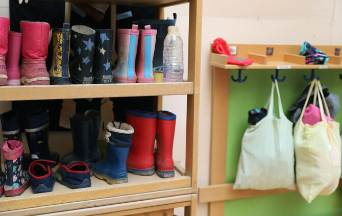 Kita Kindergarten beutel schuhe gummistiefel schuhregal symbol symbolbild symbolfoto
