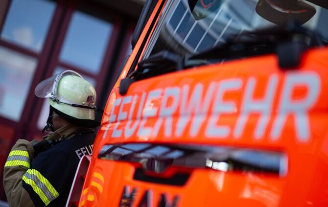 Feuerwehrmann steht neben einem Feuerwehrauto