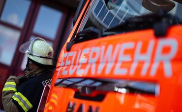 Feuerwehrmann steht neben einem Feuerwehrauto