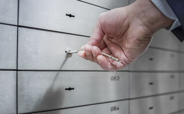 Human hand opening safe deposit box
