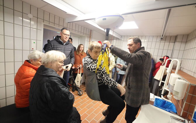 Die "Toilette für alle" ist mit einem Lift ausgestattet, den Oberbürgermeister Hartmut Holzwarth (rechts) bei der Einweihung tes
