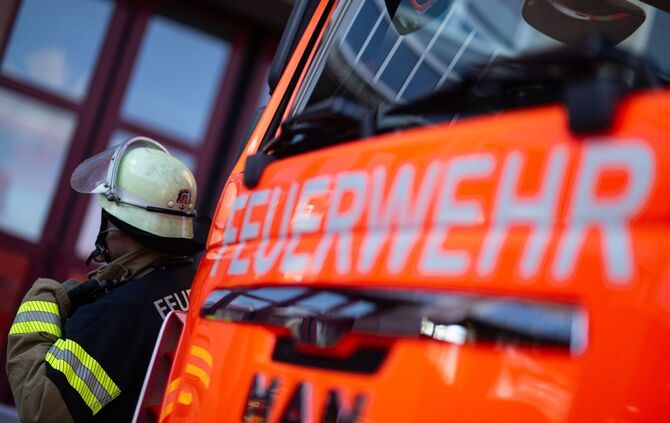 Feuerwehrmann steht neben einem Feuerwehrauto