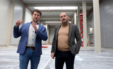 Die beiden Geschäftsführer Lukas Fried und Nicos Papadopoulos (rechts) in der neuen, elfeinhalb Meter hohen Lagerhalle, die im F