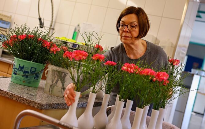 Die Blumendekoration für die Tische wird liebevoll vorbereitet.