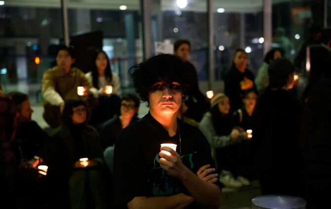 Demonstranten nehmen an einer Mahnwache bei Kerzenlicht teil.