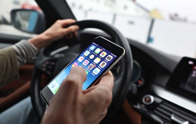 Ein «kurzer» Blick auf das Handy ist bisher erlaubt - wenn man es nicht in die Hand nimmt. (Symbolbild)