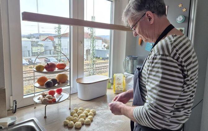 Den Hefeteig hat Markus Wagner schon vorbereitet. Jetzt werden die kleinen Teigkugeln auseinander gedrückt, damit der Teig flach