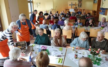 Ehrenamtliche servieren den Nachtisch beim freitäglichen "Mittagstisch" des Krankenpflegevereins.