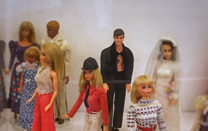 Verschiedene Barbie- und Ken-Puppen in unterschiedlichen Outfits und Rollen aus der Sonderausstellung „Barbie – Zwischen Alltag