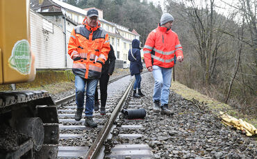 Reinhold Kasian, vorne links, und Joshua Fink, rechts, zeigen den aktuellen Stand der Sanierungsarbeiten an der Waldbahnstrecke.