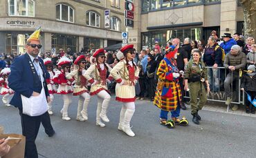 Teilnehmer des Stuttgarter Faschingsumzugs 2025 in bunten Kostümen ziehen fröhlich durch die Innenstadt.